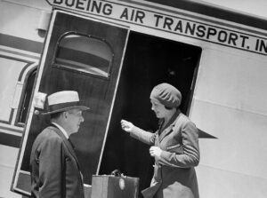 Flight attendant, greeting a passenger aboard a Model 80 aircraft of Boeing-owned airline, Boeing Air Transport